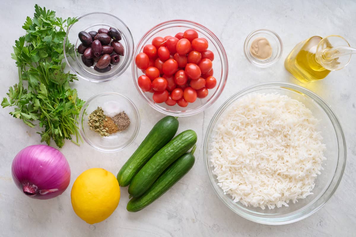 Ingredients to make recipe: fresh parsley, red onion, lemon, spices, kalamata olives, grape tomatoes, Persian cucumbers, basmati rice, Dion mustard and oil.