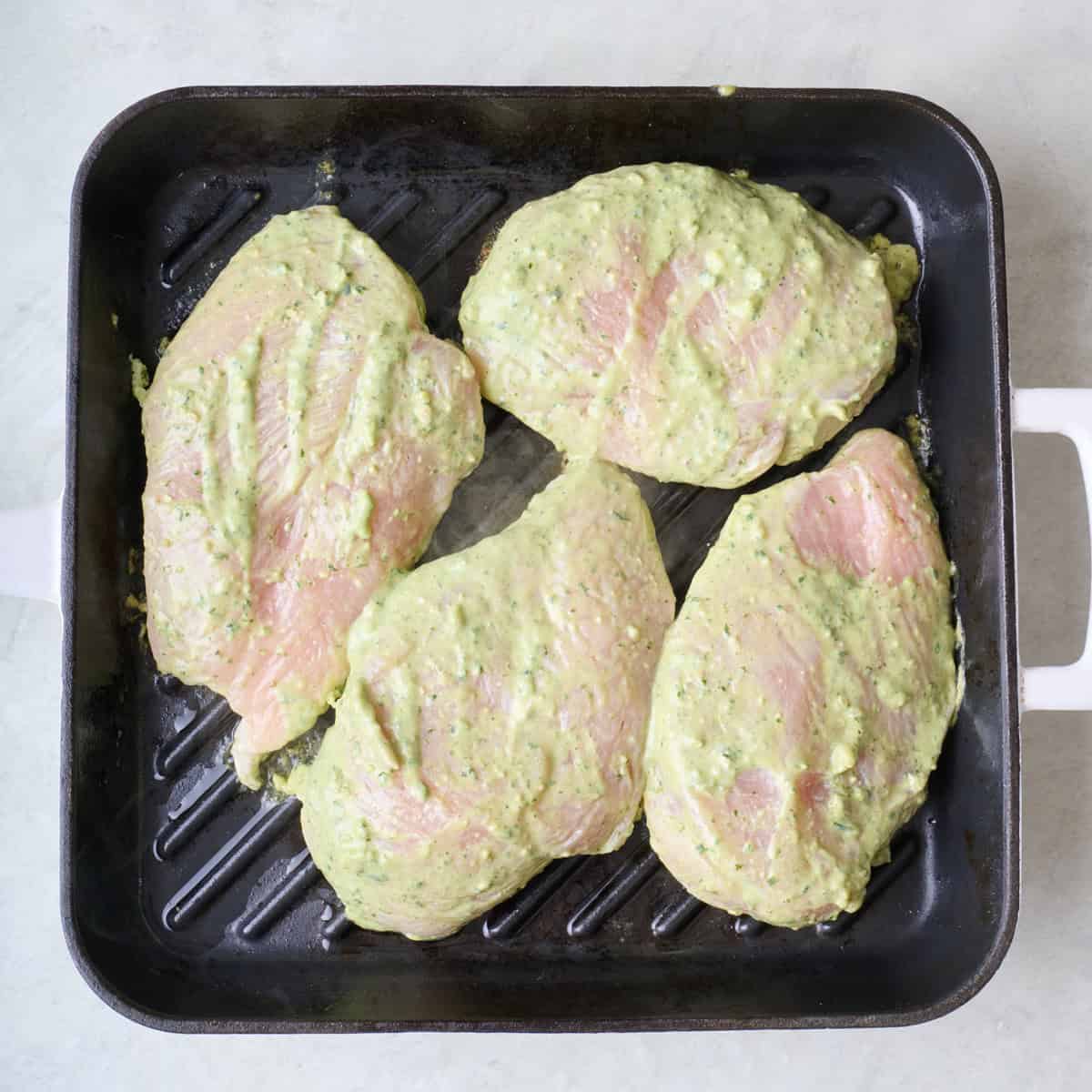 Marinated chicken breast on a grill pan.