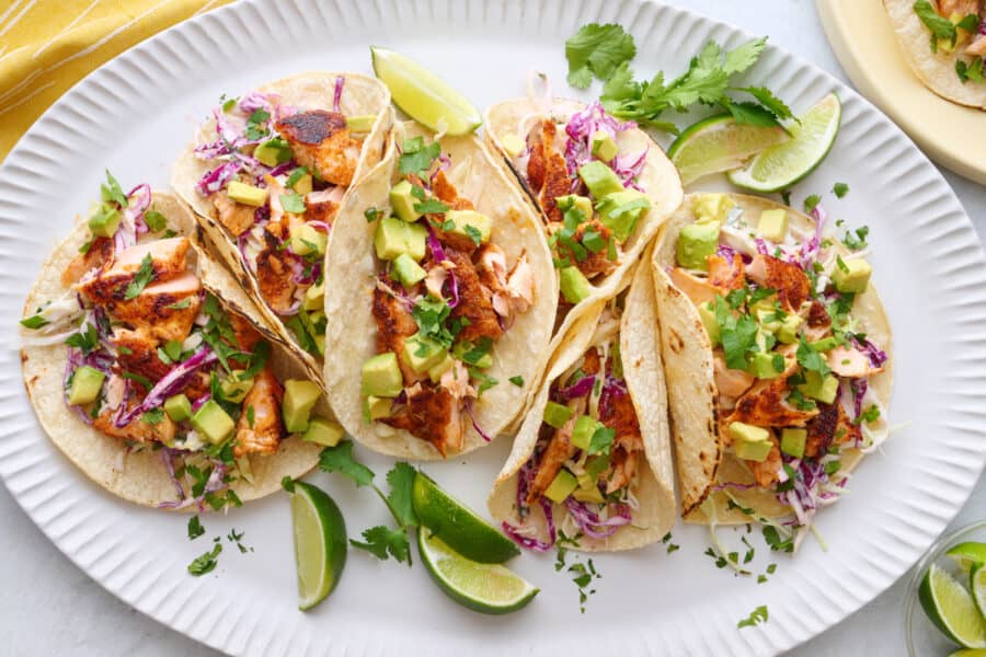salmon tacos on a plate with lime wedges