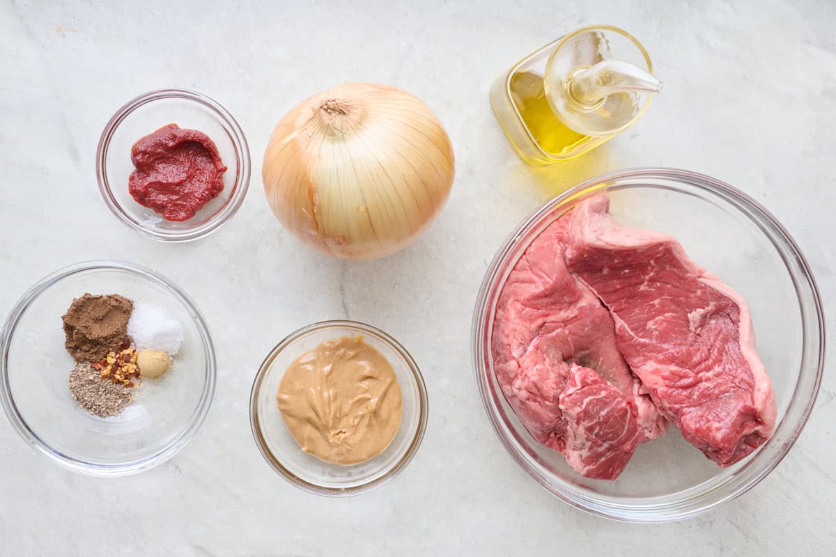 Ingredients for recipe: sirloin steak, onion, peanut butter, tomato paste, onion, oil, and spices.