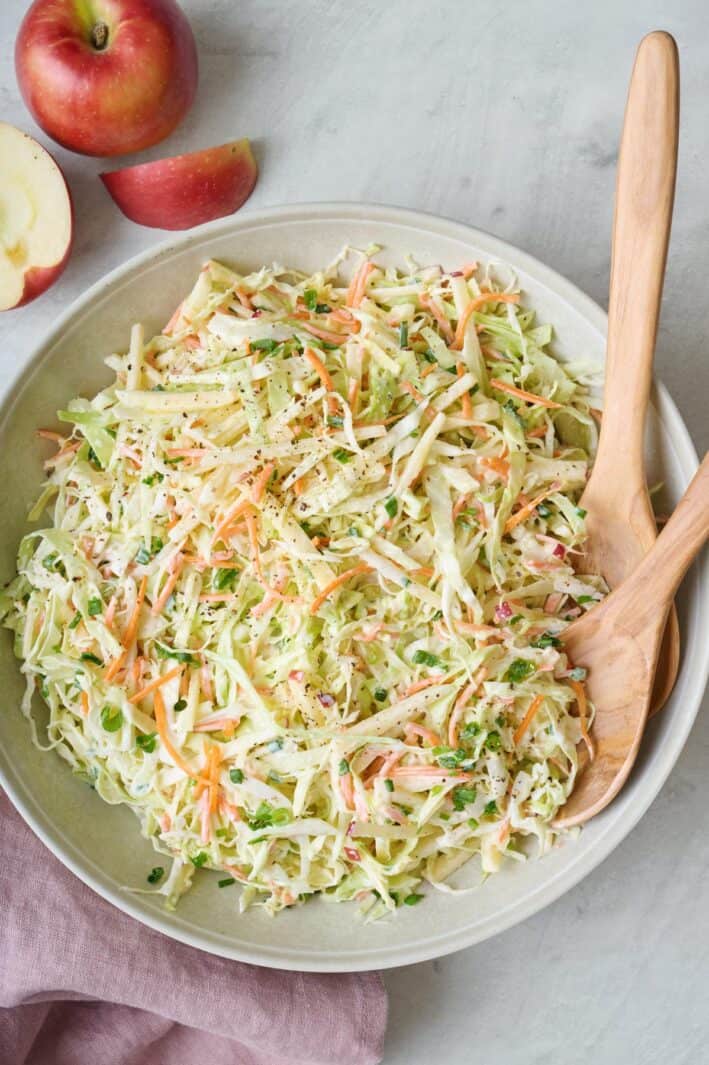 Homemade crunchy apple slaw recipe in a serving bowl.