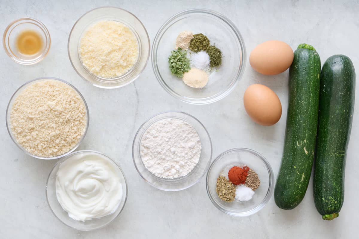 Baked zucchini fries ingredients on a marble countertop.