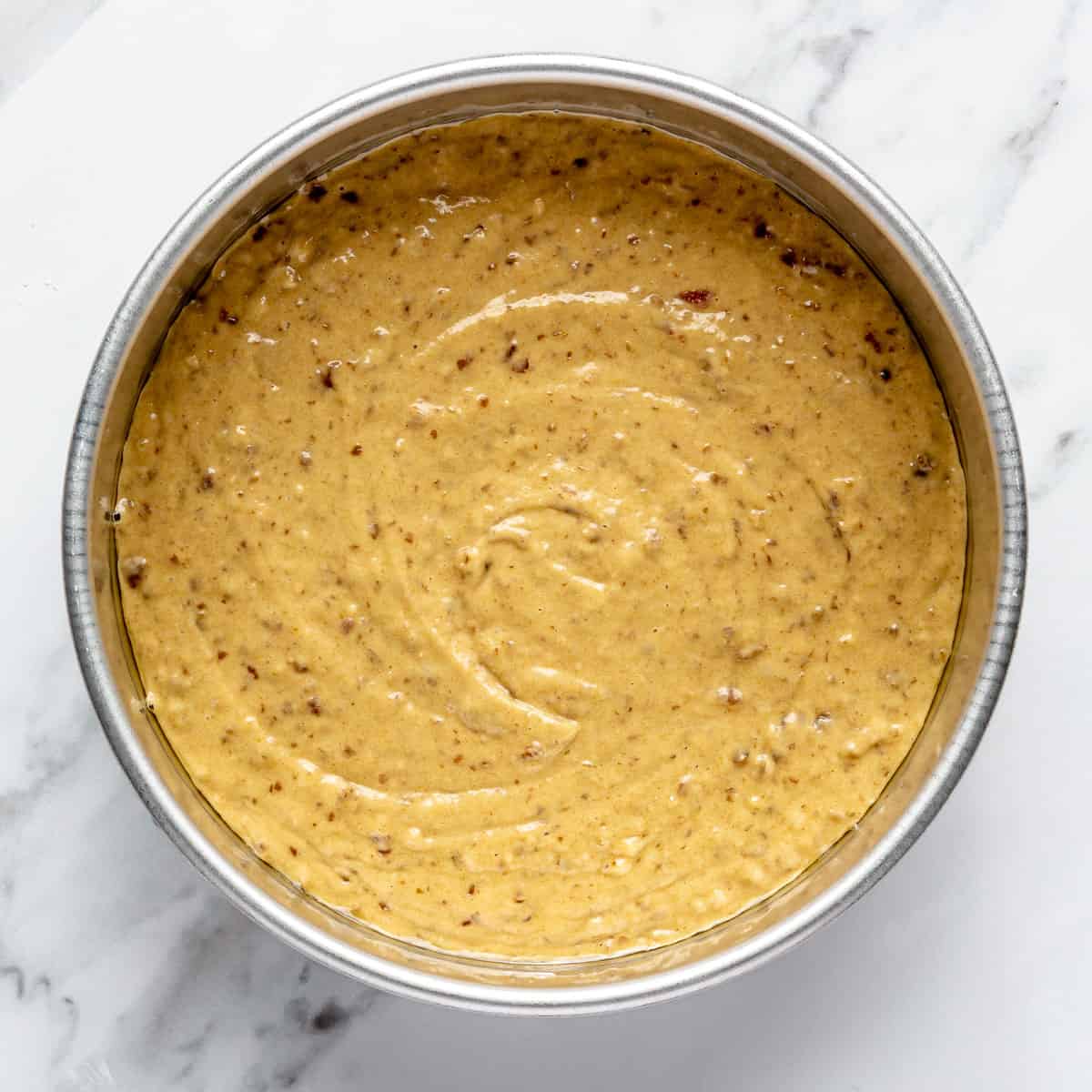 Cake batter in a round cake pan.