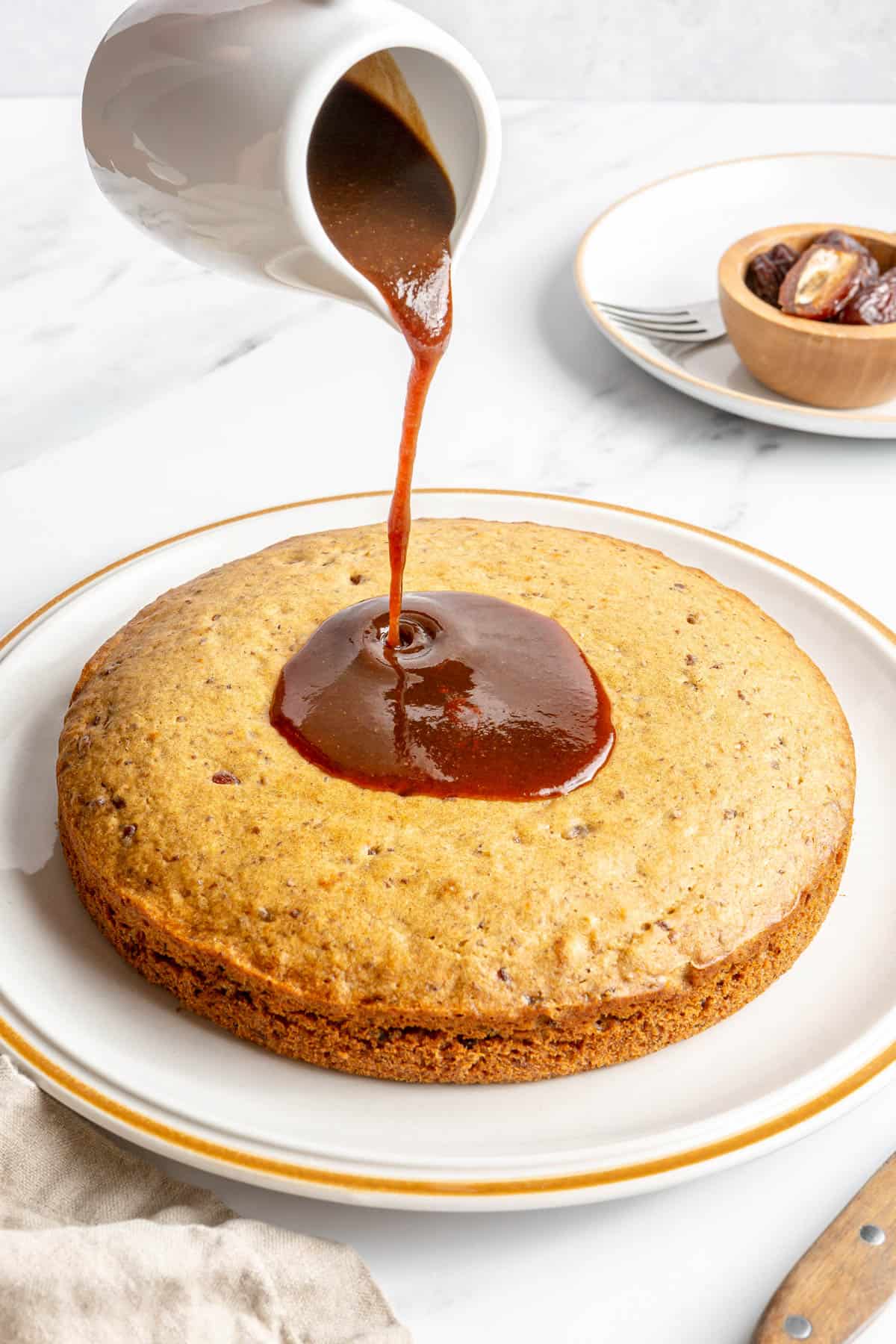 Pouring date syrup on top of date cake.