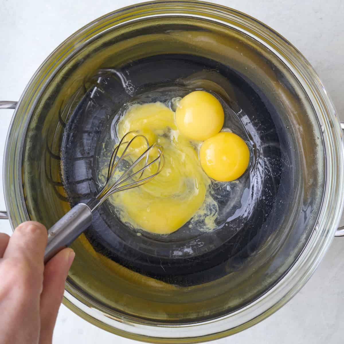 Whisking partially mixed ingredients together.