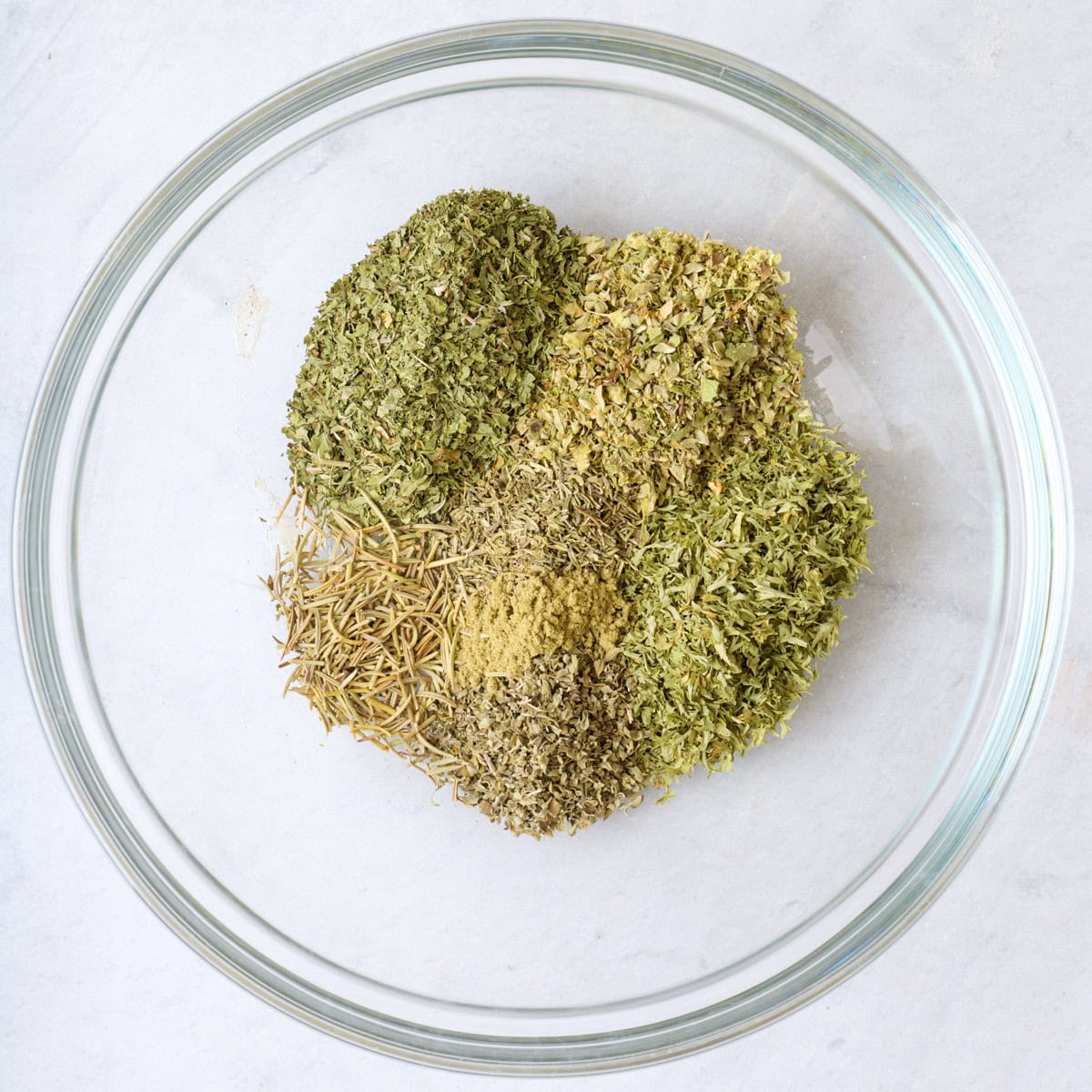 Dried herbs in a small bowl before mixing.