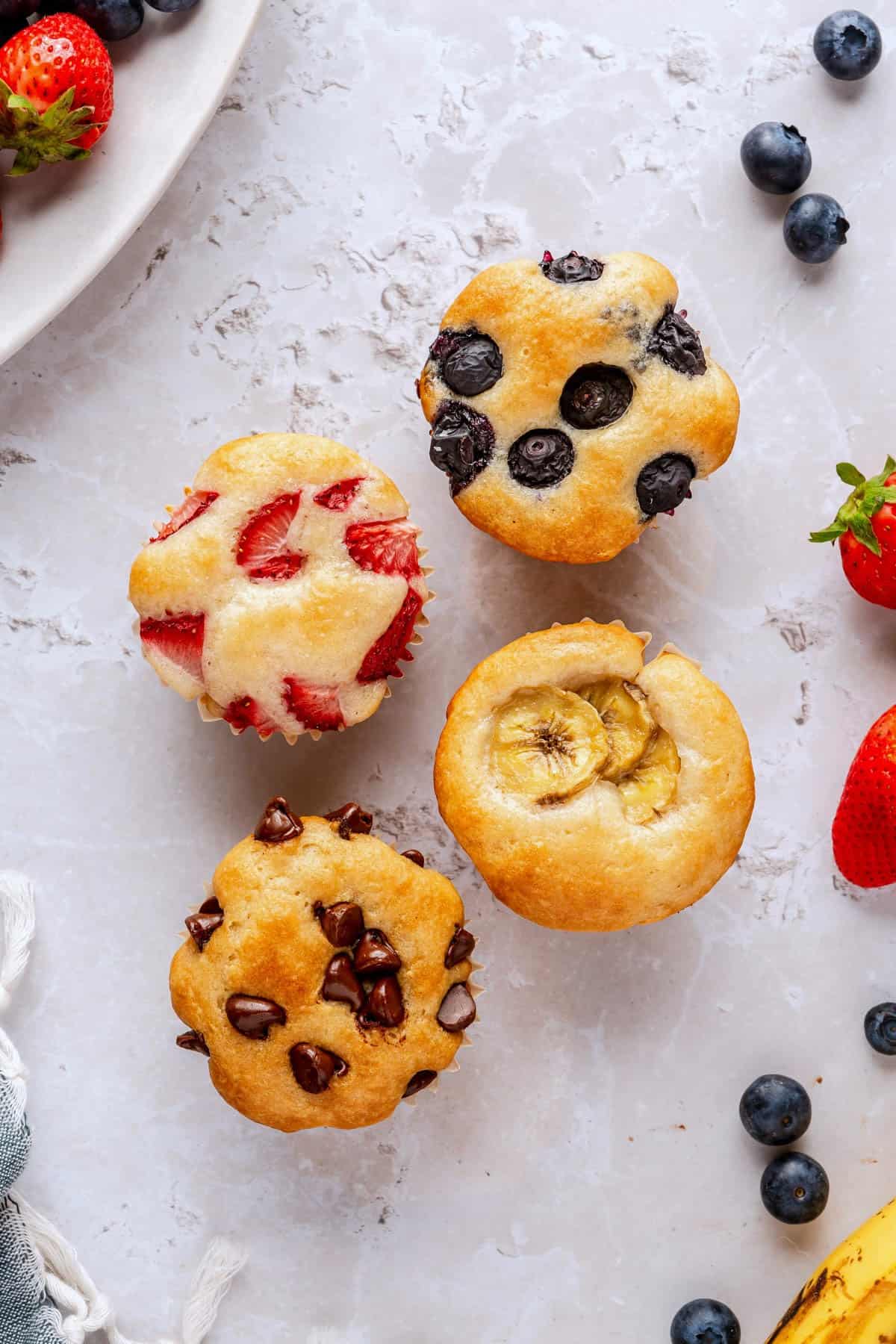 Four different pancake muffins: strawberry pancake muffin, blueberry pancake muffin, chocolate chip pancake muffin, and a banana pancake muffin.