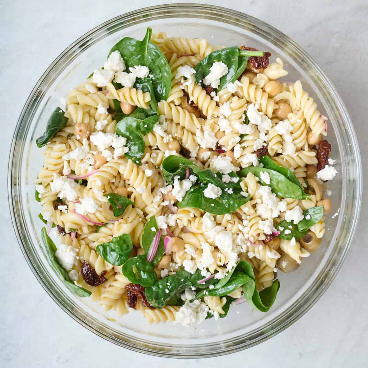 Sun-dried tomato pasta salad topped with crumbled feta cheese.