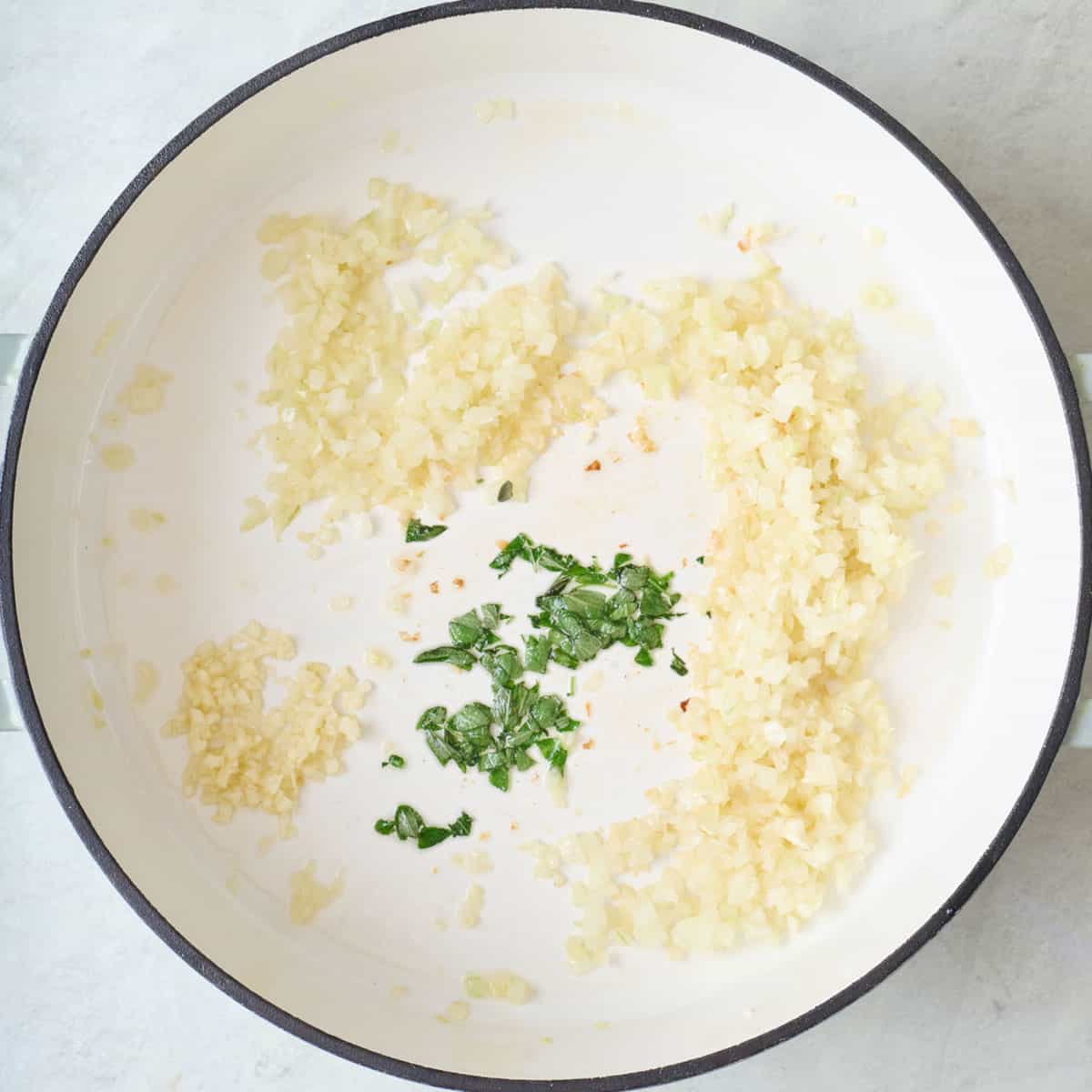 Onions, garlic, and sage in a pot.