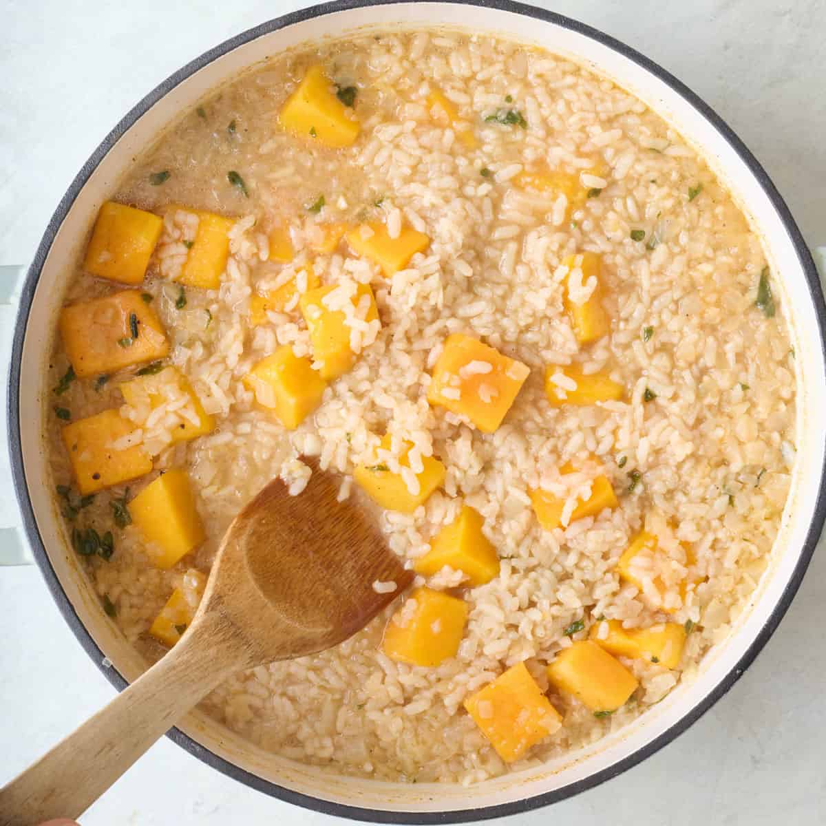 Stirring rice and squash halfway through cooking.