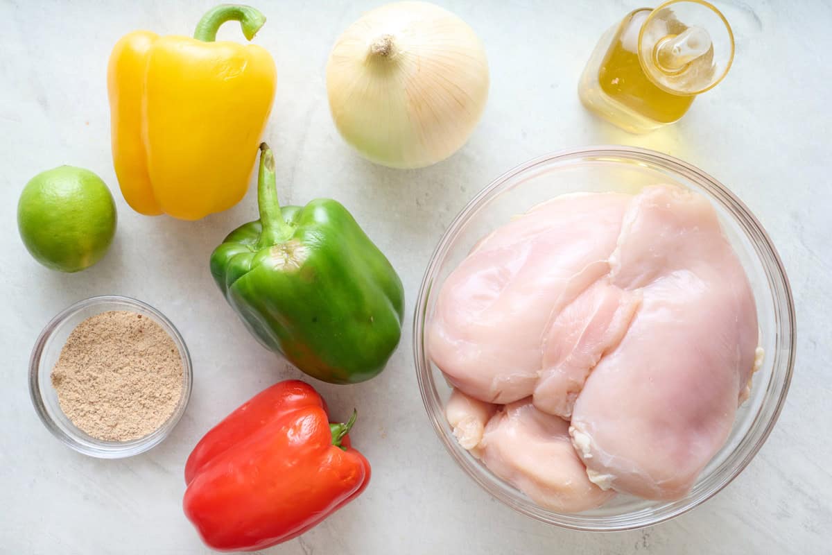 Ingredients for recipe: chicken breasts, bell peppers, onions, fajita seasoning, lime, and oil.