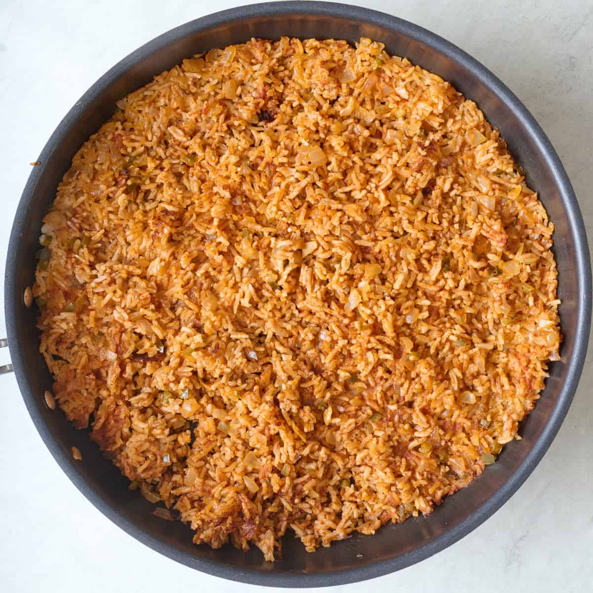 Fully cooked spanish rice in a skillet.