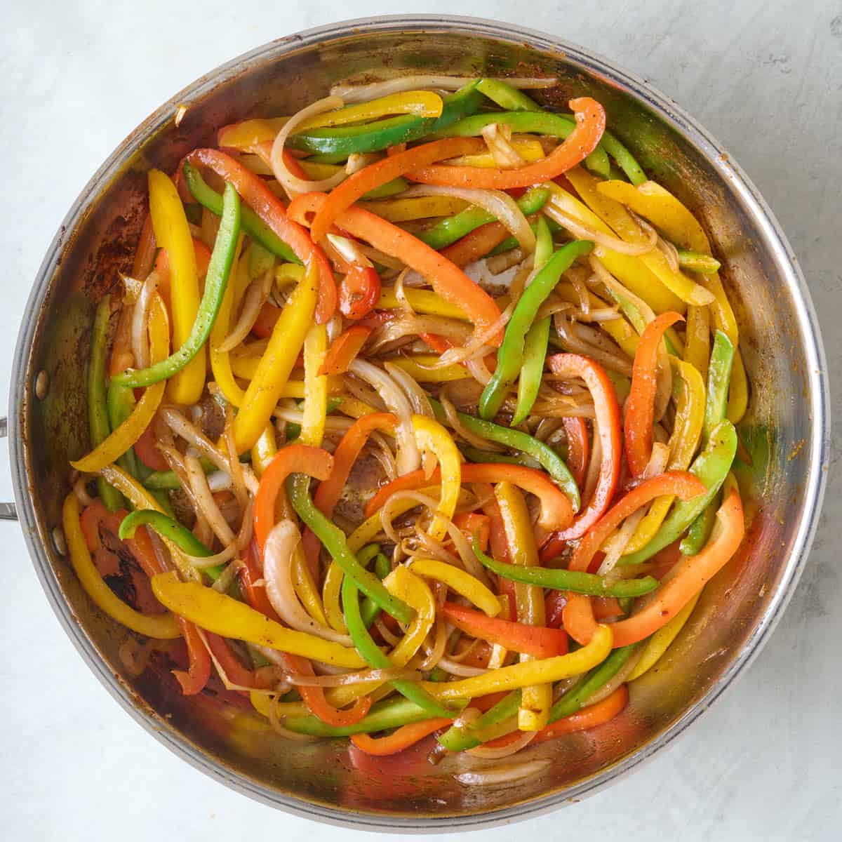 Peppers added to onions in skillet.