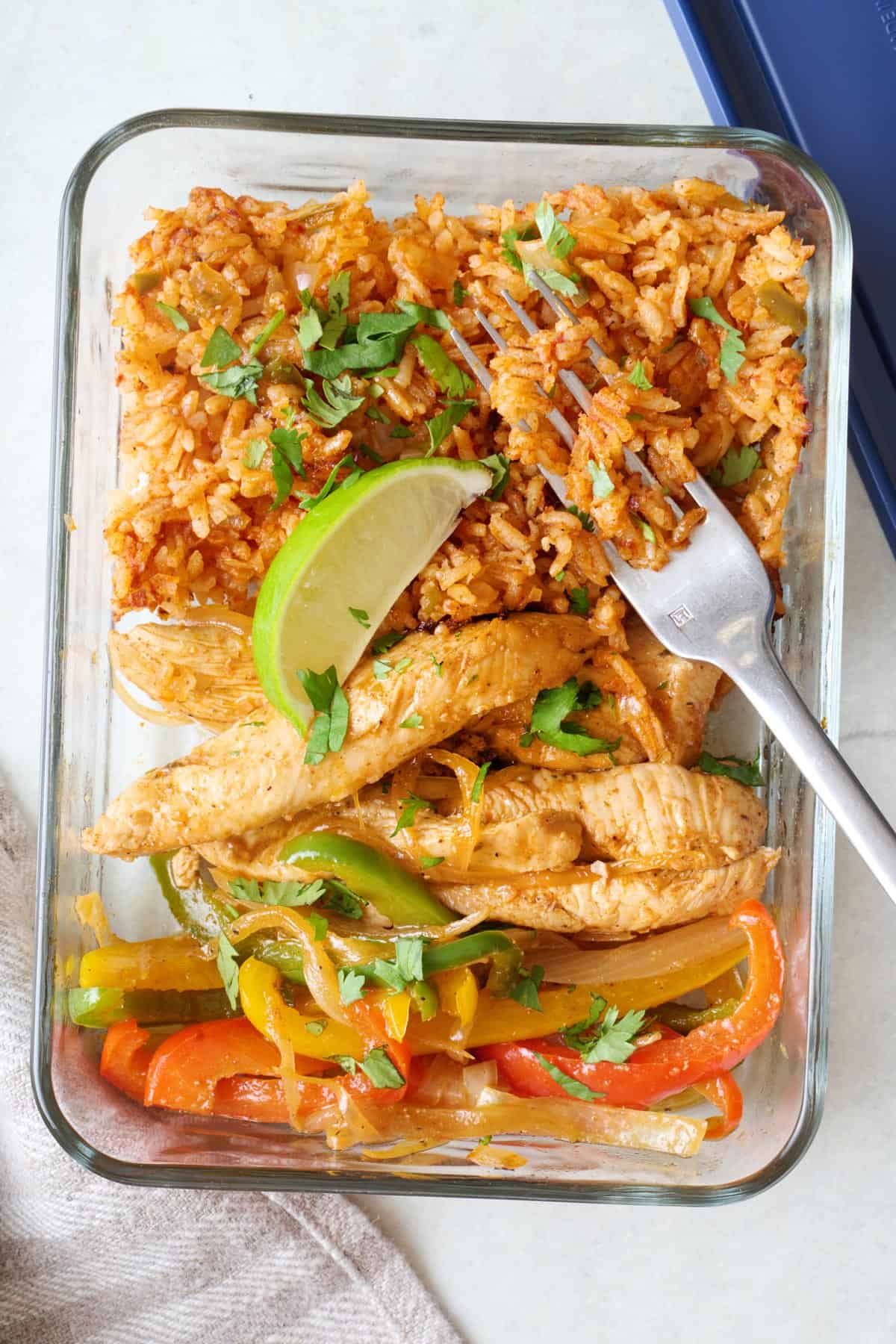 Meal prep container filled with chicken fajitas and rice.