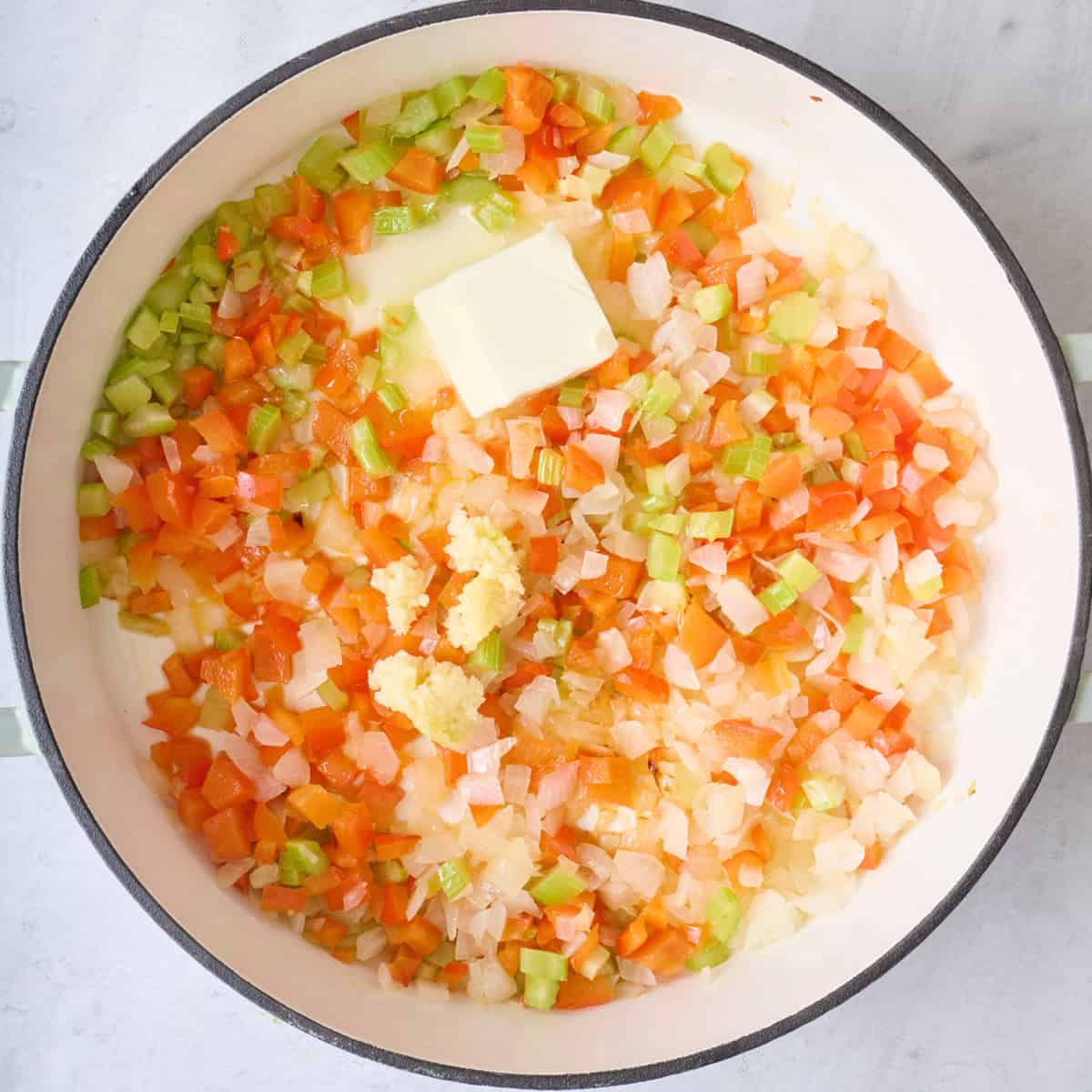 Onion, pepper and celery in an oiled pot after cooking veggies with garlic and butter added.