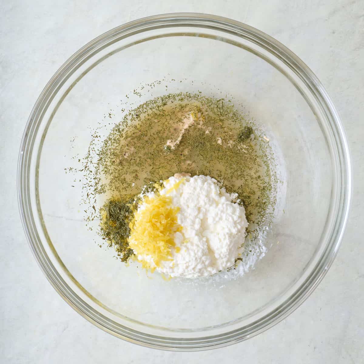 Cottage cheese, lemon zest and juice, Dijon mustard, dill, salt and pepper in a bowl before combining.