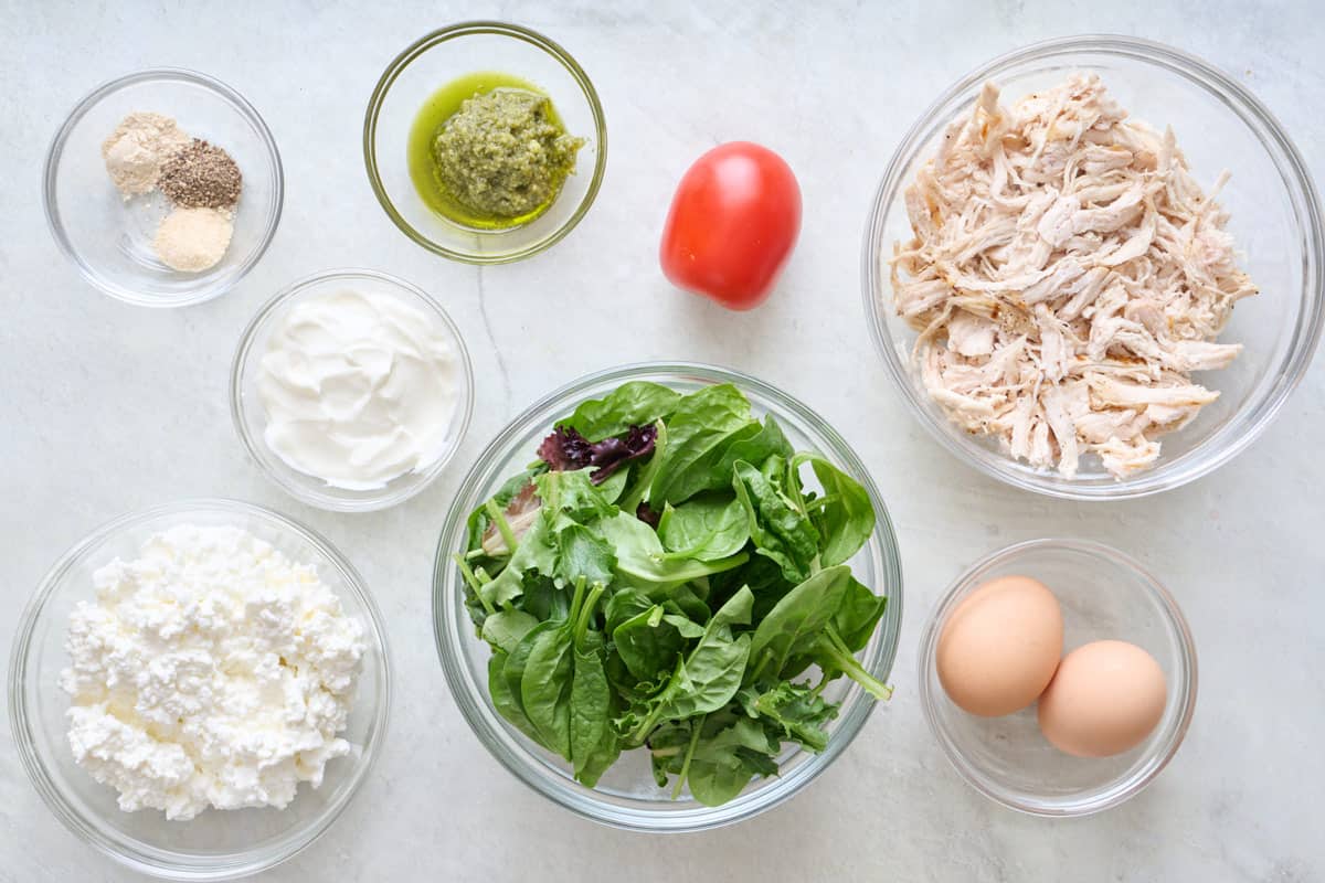 Ingredients for recipe: cottage cheese, yogurt, pesto, seasonings, mixed greens, shredded chicken and eggs.