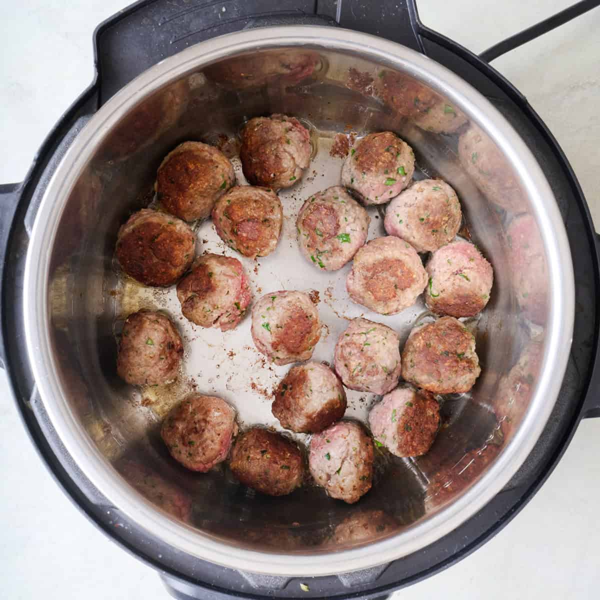 Meatballs in an Instant Pot after browning on each side.