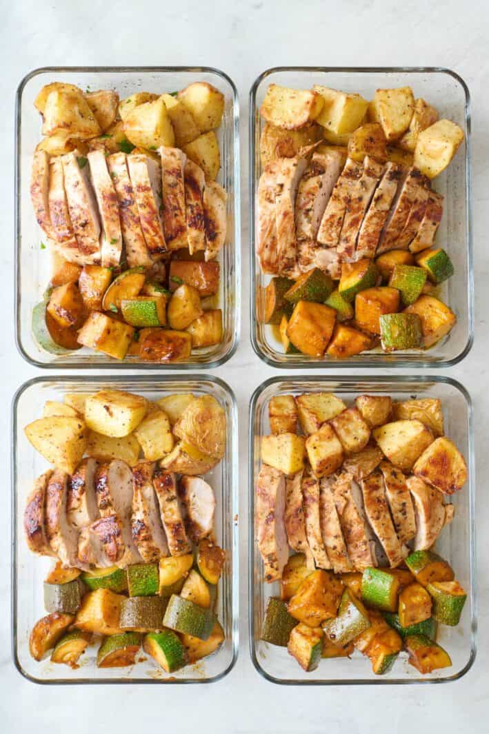 Lemon garlic meal prep containers with seasoned potatoes and zucchini.