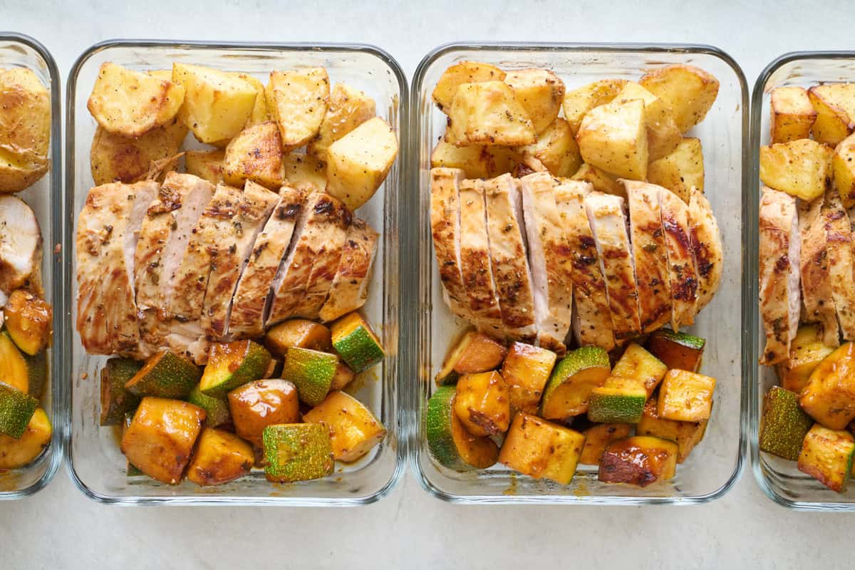 Lemon garlic meal prep containers with seasoned potatoes and zucchini.