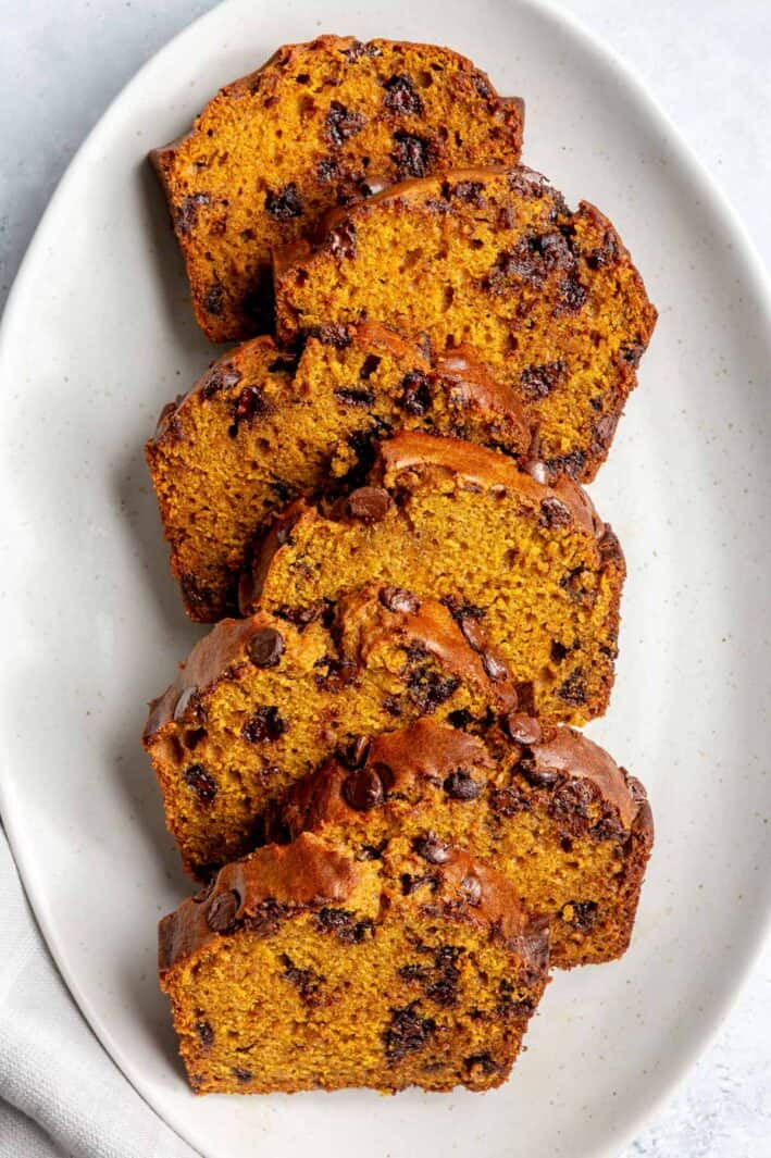 Thick slices of chocolate chip pumpkin bread fanned out on a platter.