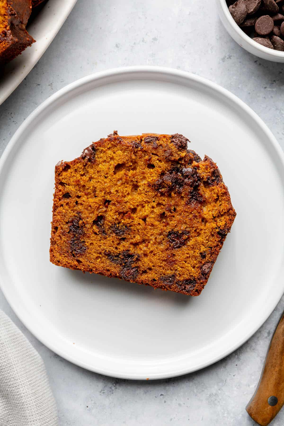 Slice of pumpkin bread with chocolate chips on a plate.