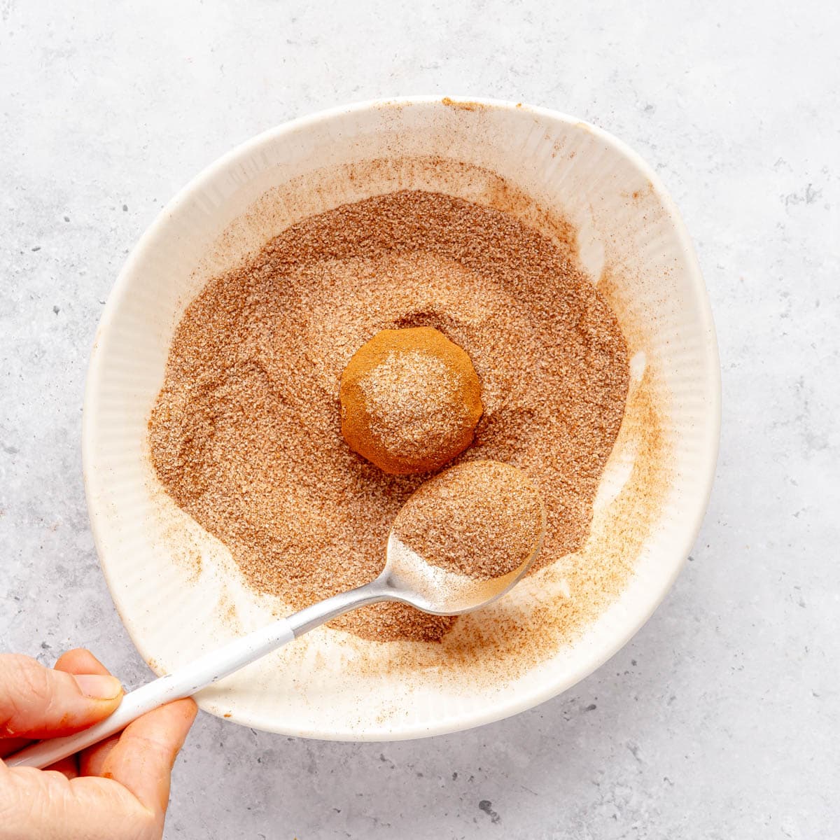 Rolling in the cinnamon sugar mixture.