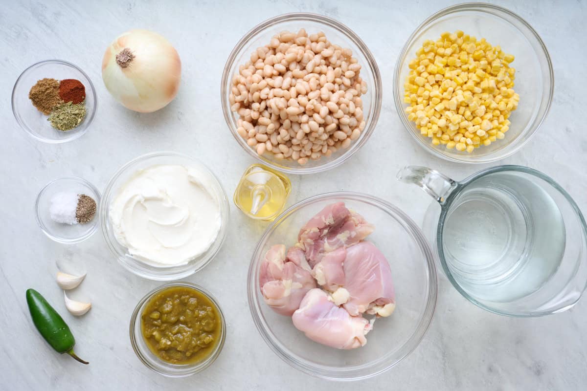 Ingredients for recipe: onion, jalapeno, garlic, chicken thighs, seasoning, white beans, sour cream, green chilis, corn, shredded cheese.