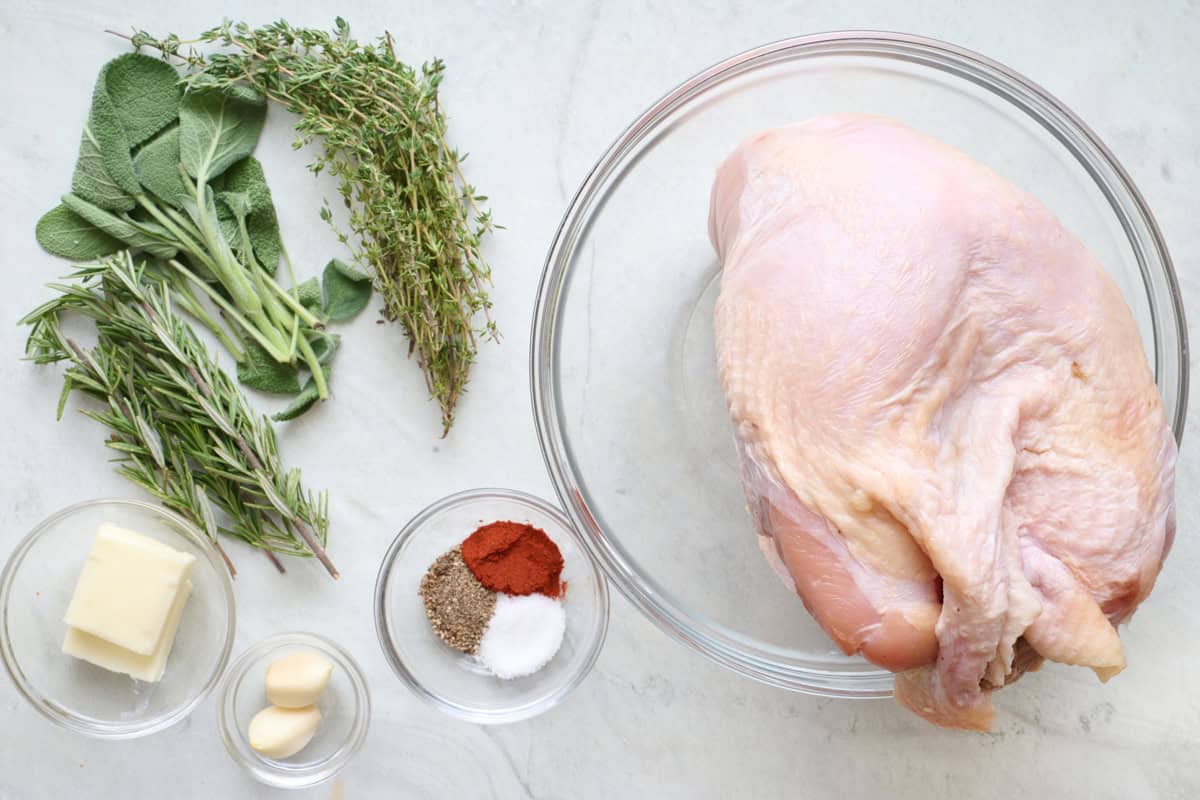 Ingredients for recipe: bone in turkey breast, fresh rosemary, sage and thyme, butter, garlic, salt, pepper, and paprika.