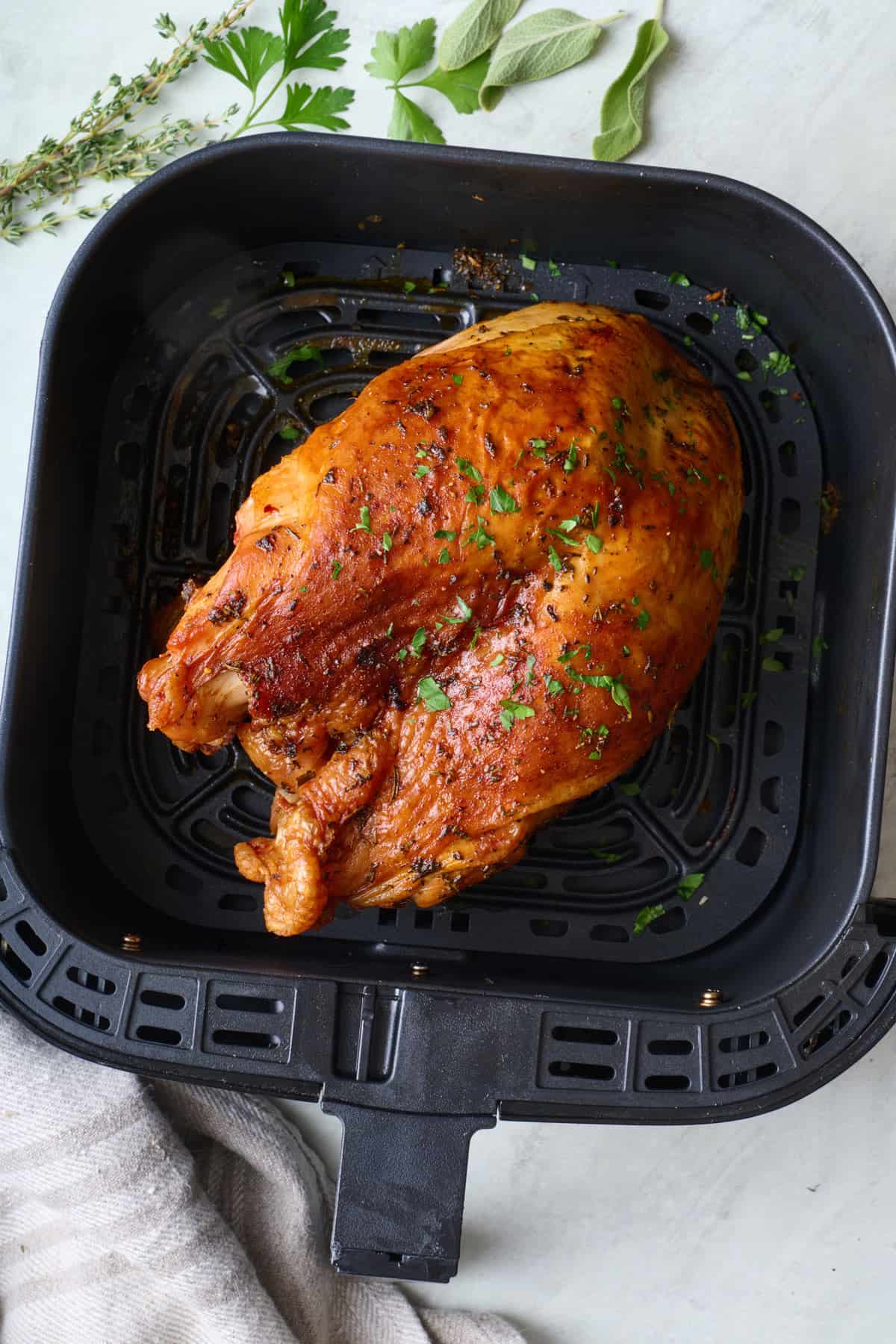 Air fryer turkey breast in basket.