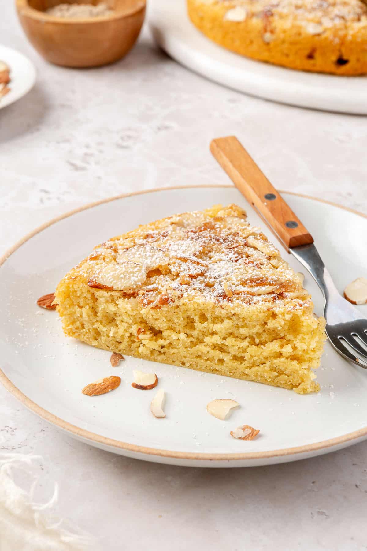 Side view of cardamom cake dusted with powder sugar to show texture.