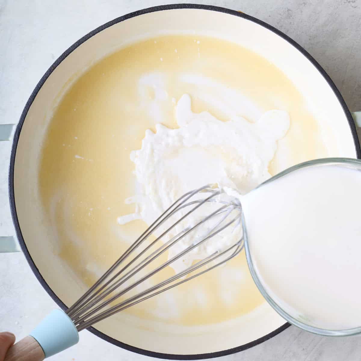 Whisking milk into roux.