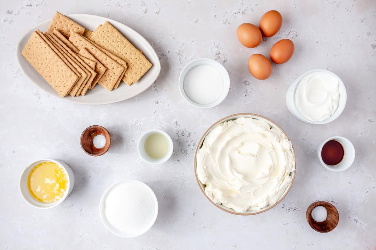 Ingredients for recipe: graham cracker sheets, eggs, sugar, butter, salt, lemon juice, cream cheese, sour cream cream, vanilla, and salt.