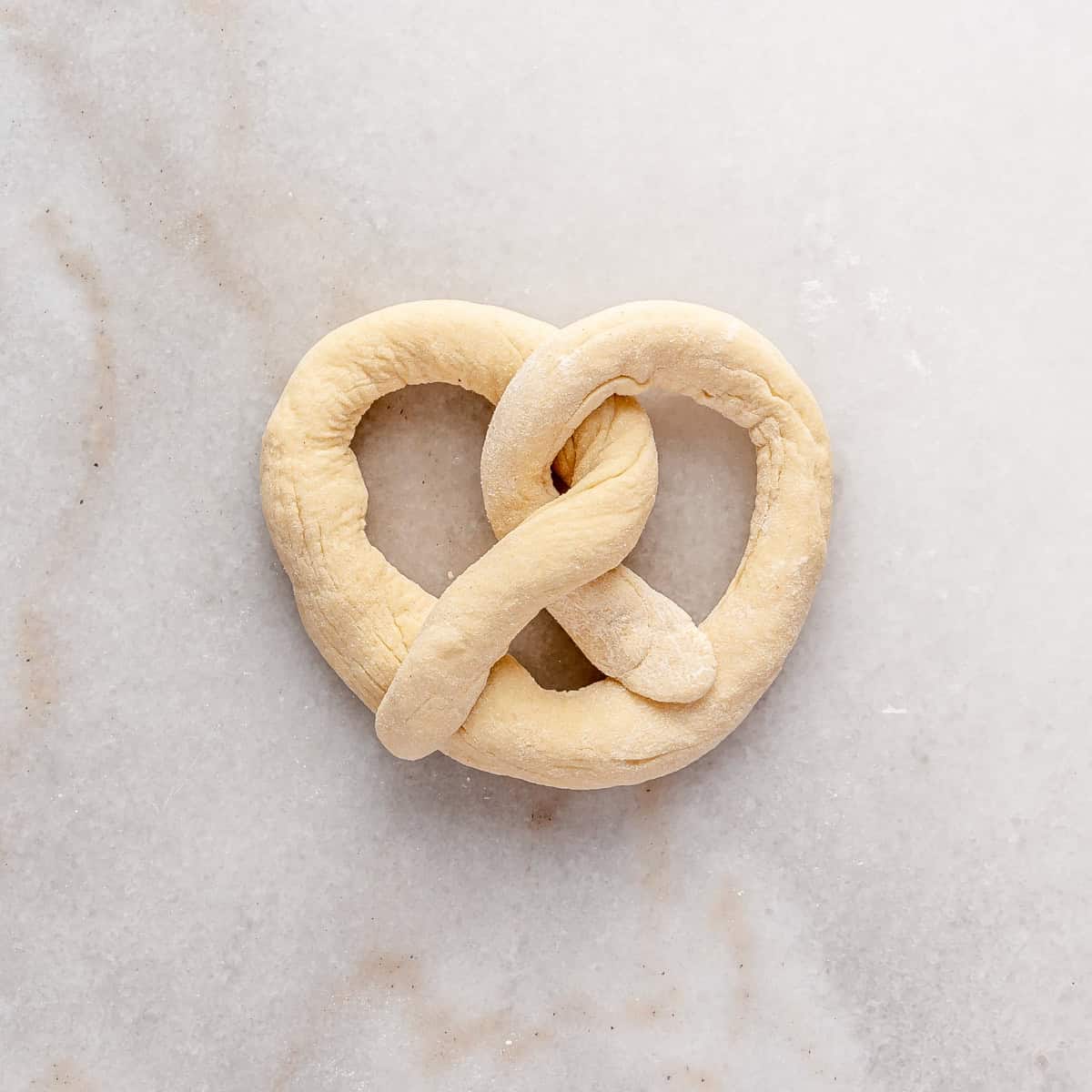 After bring the twisted ends forward in a pretzel shape.