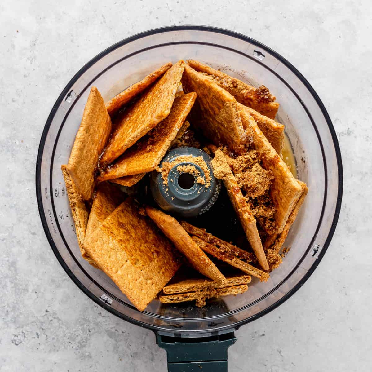 Graham cracker crust ingredients in the bowl of a food processor.