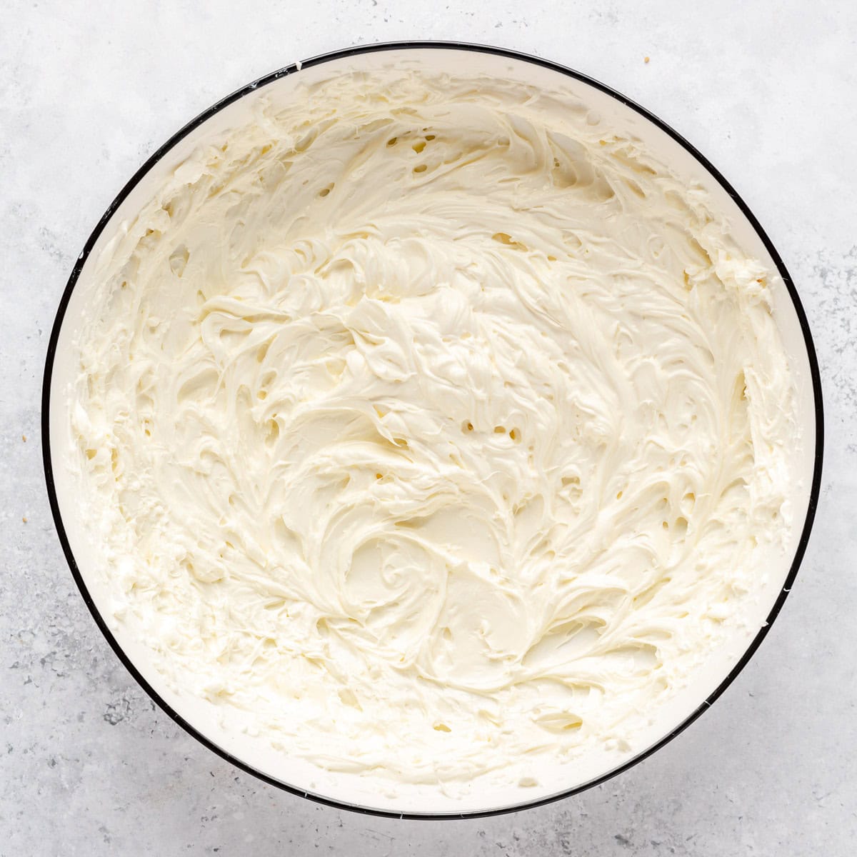 Cream cheese in a bowl after mixing until light and fluffy.