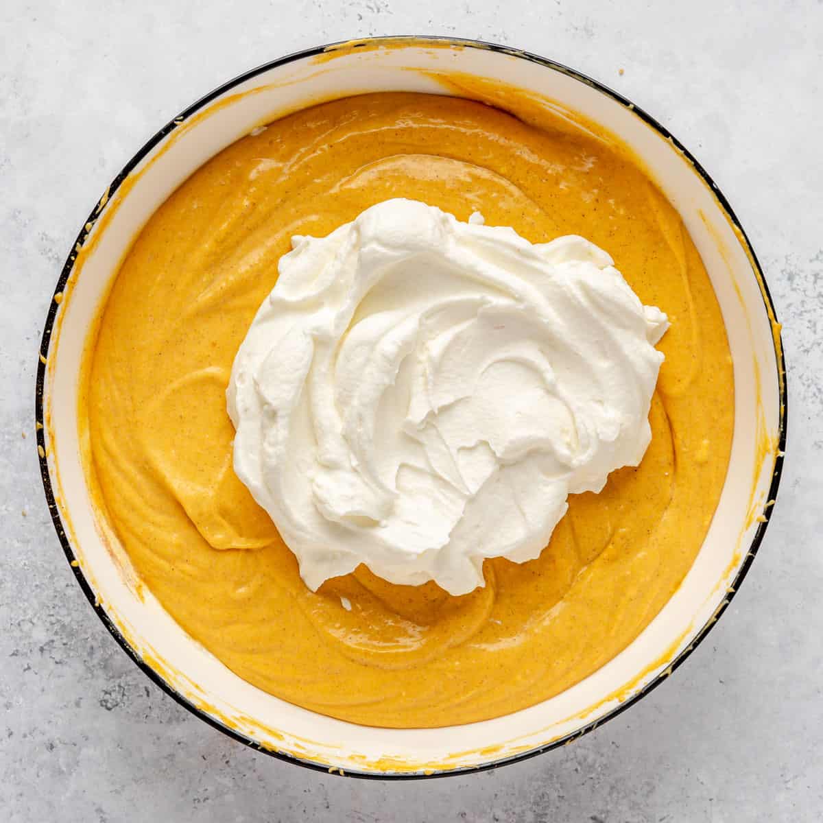 Whipped cream added on top of pumpkin mixture.