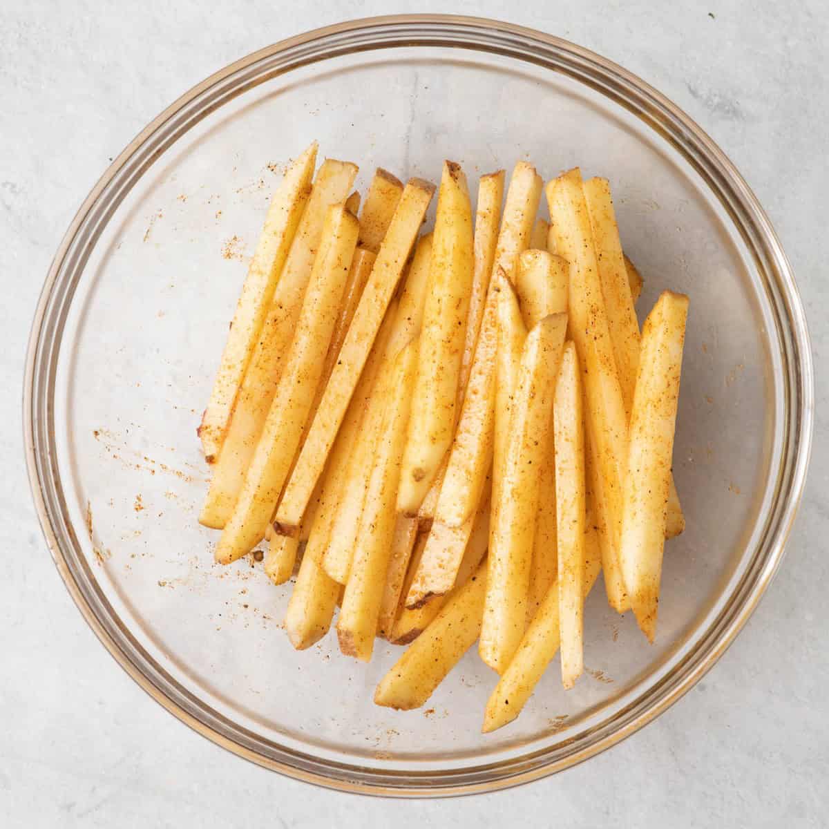 Cut potato sticks coated in seasoning and oil.