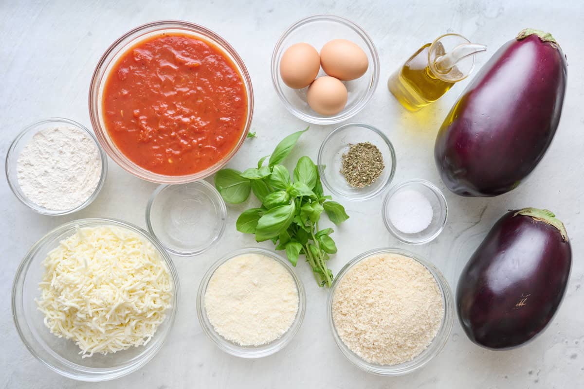 Ingredients for recipe: flour, shredded cheese, marinara sauce, eggs, fresh basil, grated parmesan, salt italian seasonings, breadcrumbs, oil, and eggplants.