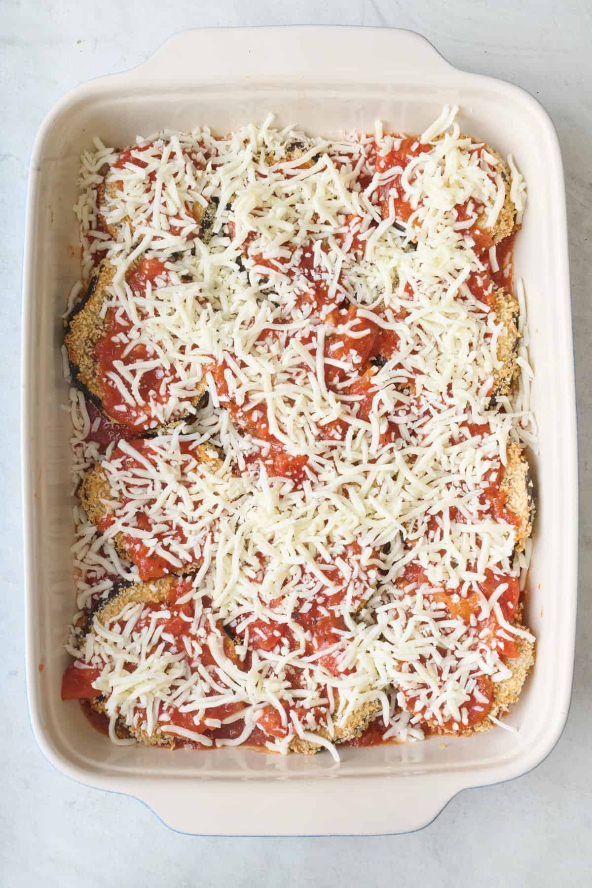 Shredded cheese added on top of sauce.