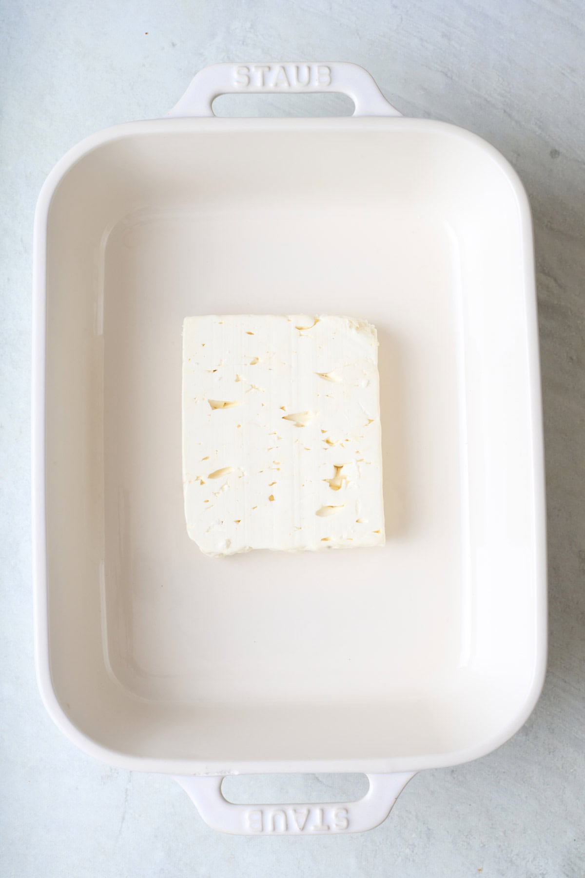 Block of feta in a baking dish.