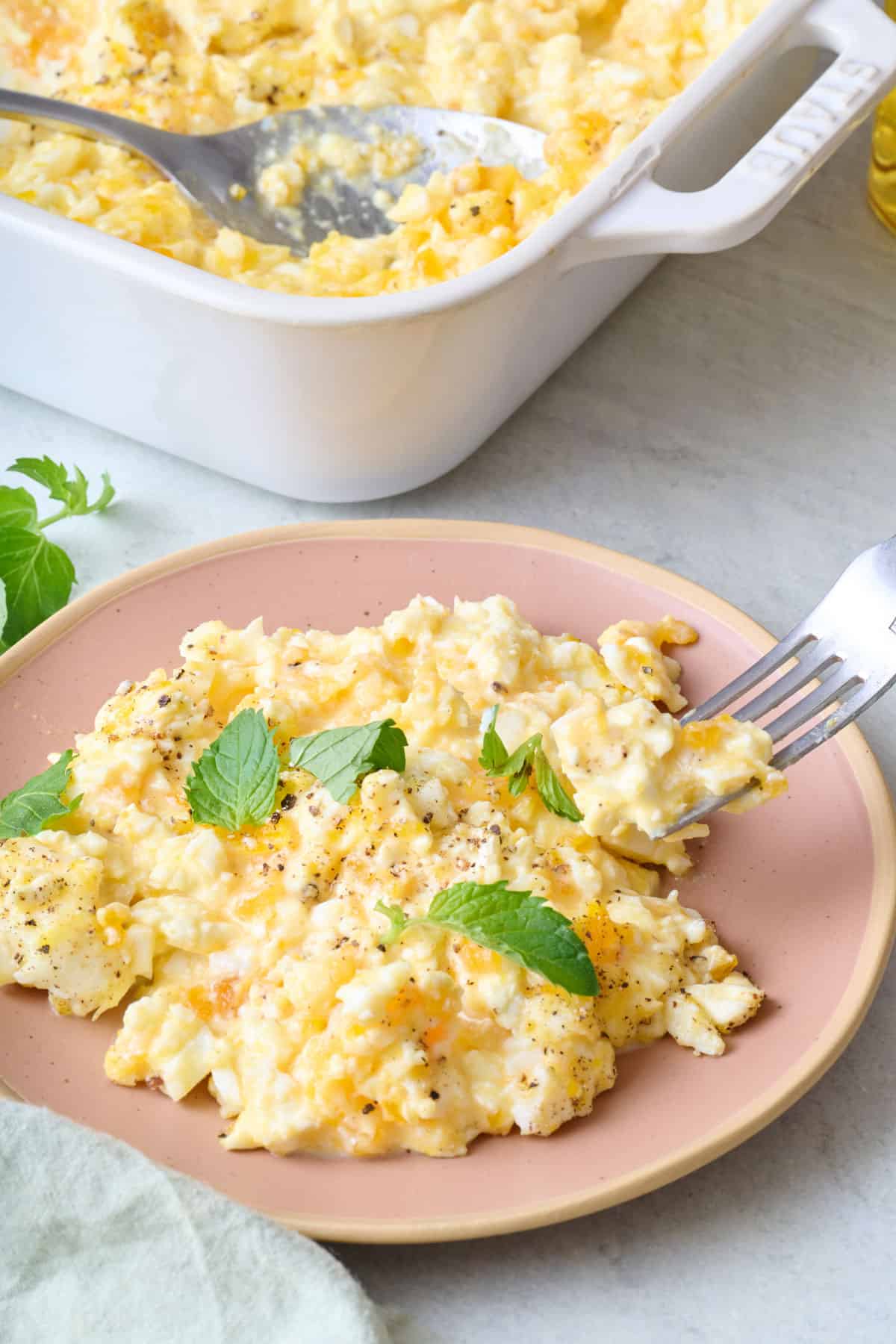 Feta baked scrambled eggs on a plate with fresh mint.