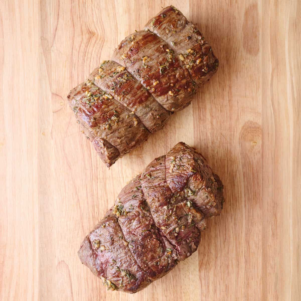 Tenderloin roast after roasting and resting on a cutting board with twine removed.