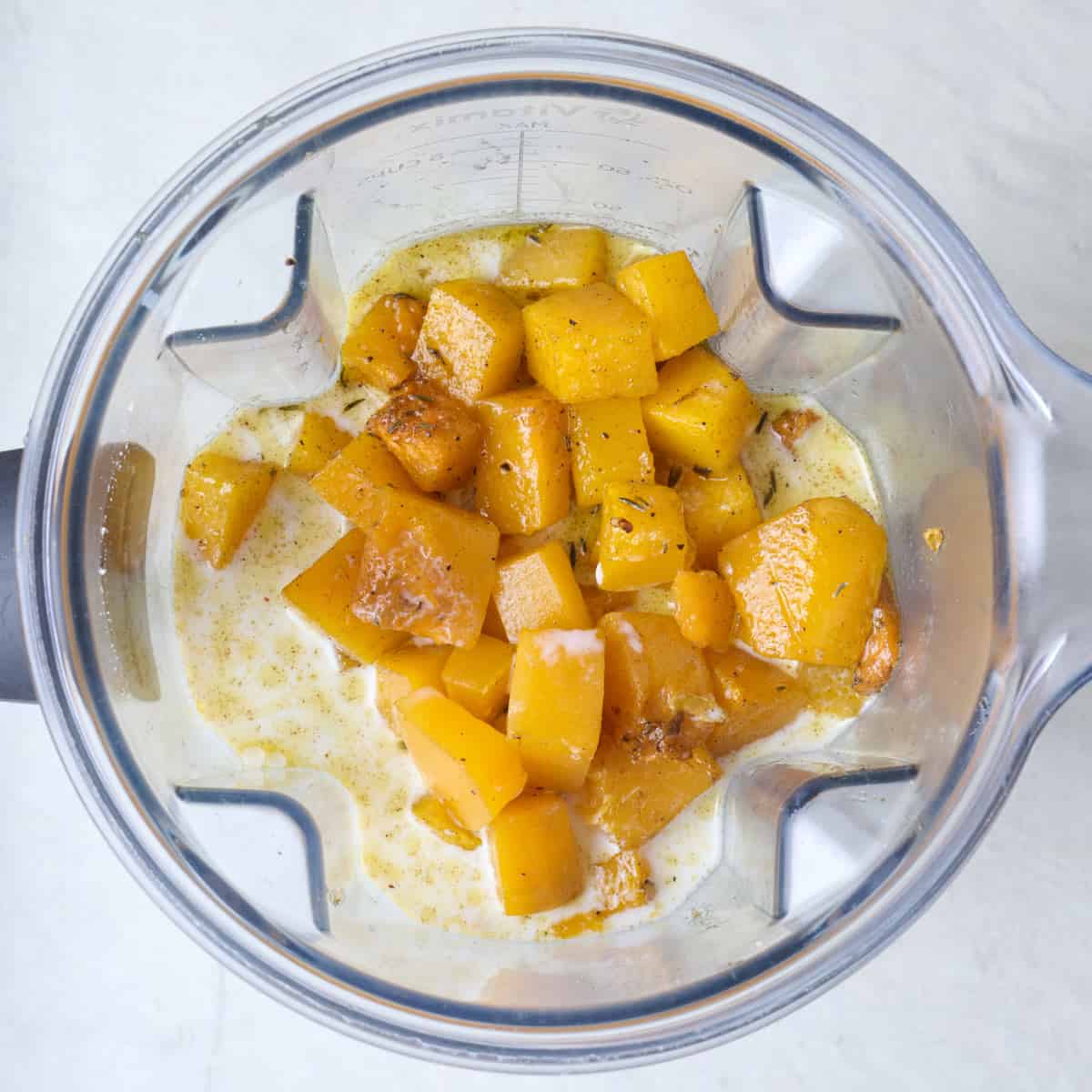 Roasted butternut squash in a blender with with milk.