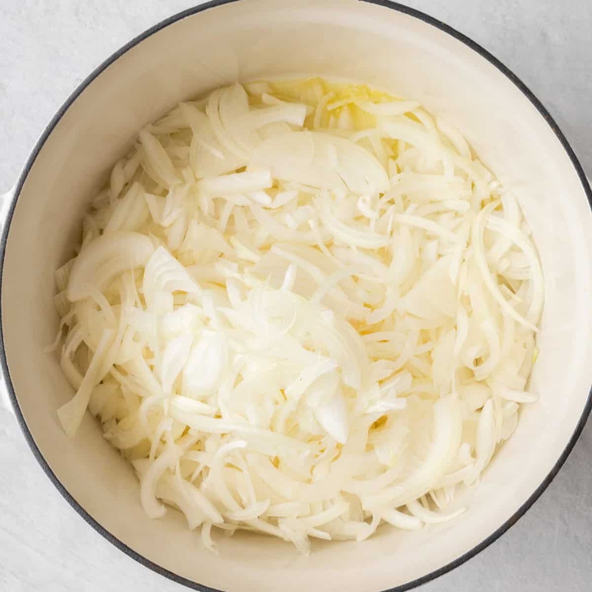 Sliced onions in a pot with butter.