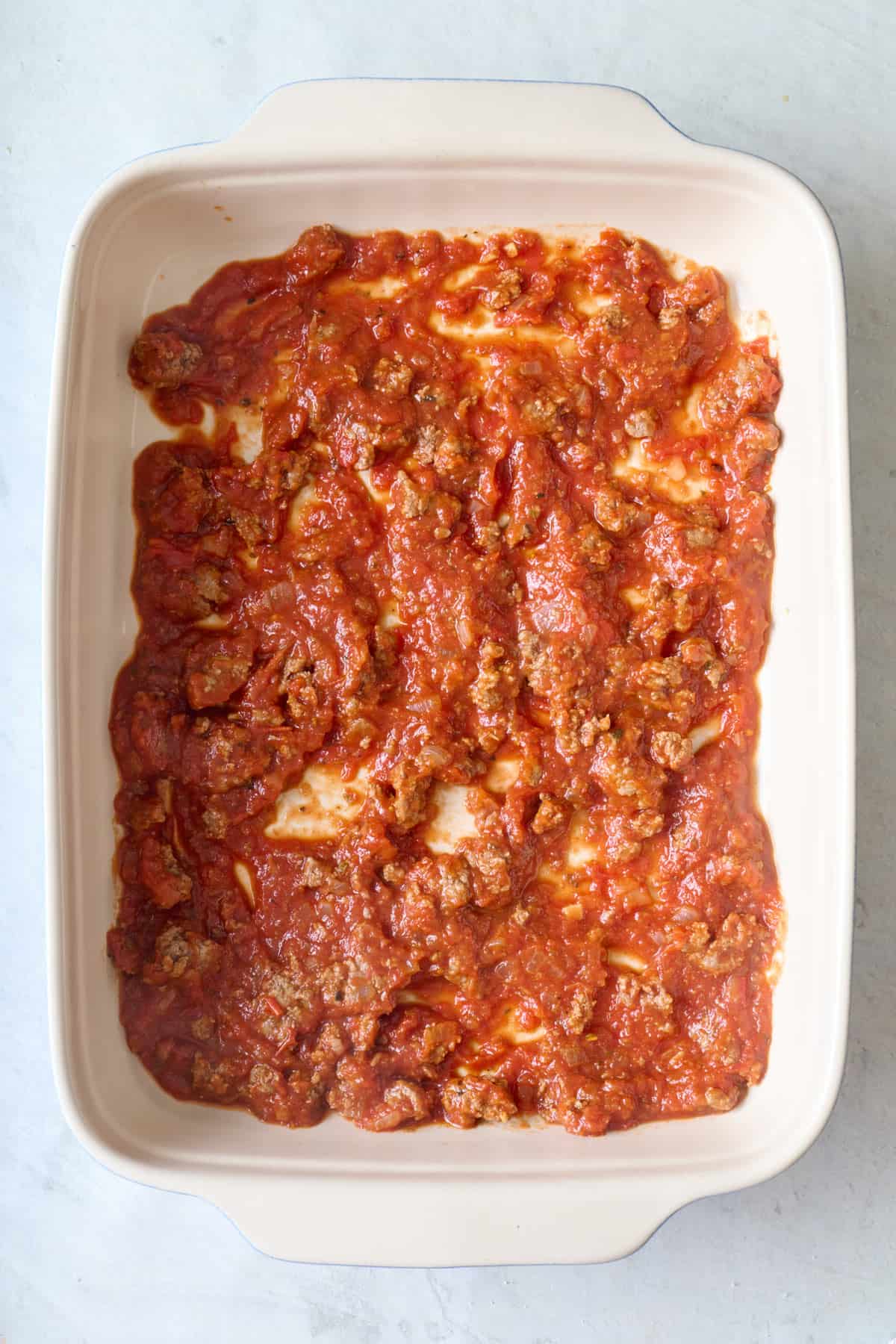 Meat sauce spread in a baking dish.