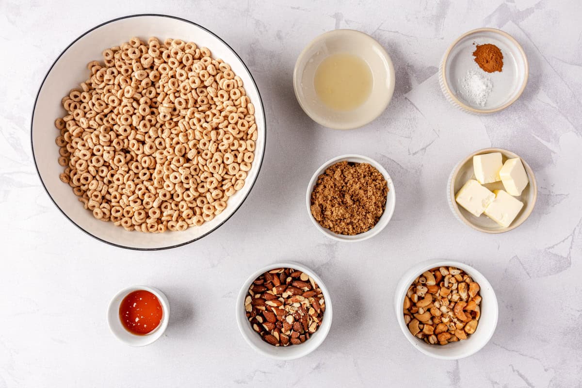 Ingredients for recipe in individual bowls: Cheerios cereal, honey, lemon juice, brown sugar, nuts, cinnamon, and butter.