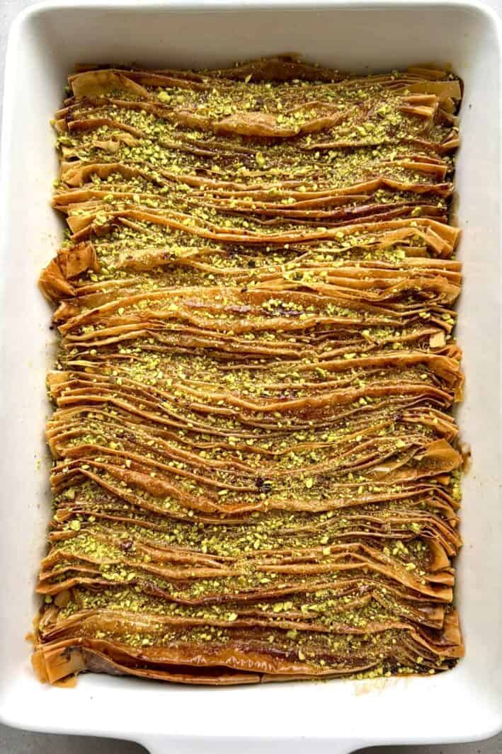 Phyllo crinkle cake in a baking dish with chopped pistachios.