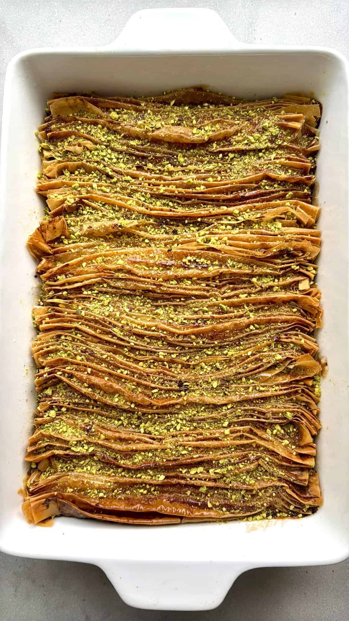 Phyllo crinkle cake in a baking dish with chopped pistachios.