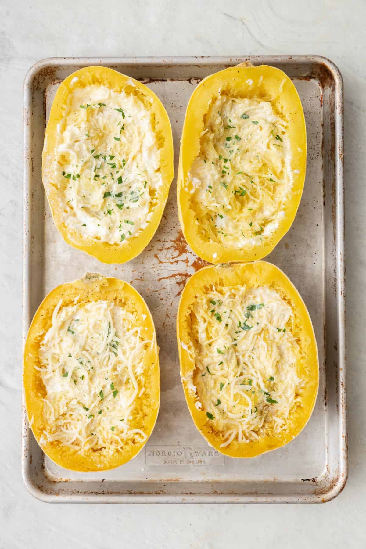 Alfredo sauce and parsley on top of each spaghetti squash boat after tossing together.